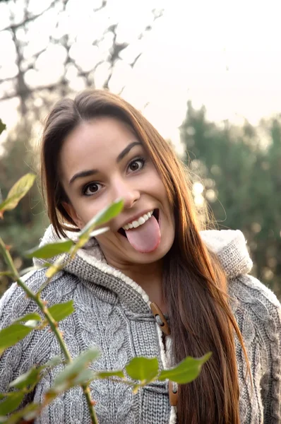 Young female making funny face with tongue out — Stock Photo, Image