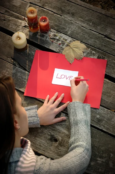 View over the shoulder of a woman writing word LOVE — Stock Photo, Image