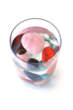Crystals in full filled glass of water, on white, top view clipart
