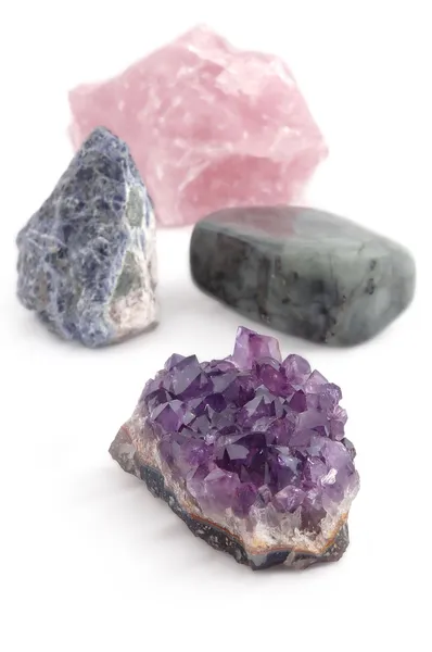 Четыре больших различных драгоценных камня (кристаллы) на белом фоне — стоковое фото