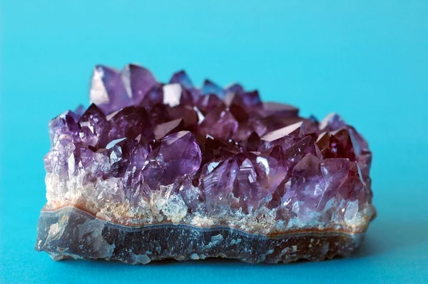 Lila Kristall Amethyst auf blauem Hintergrund — Stockfoto