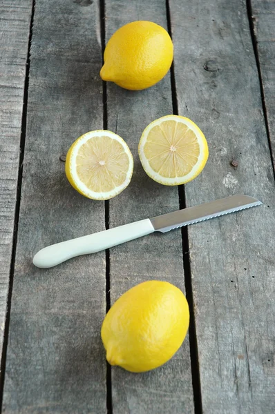 Celá a řez citronu s nožem na šedém pozadí — Stock fotografie
