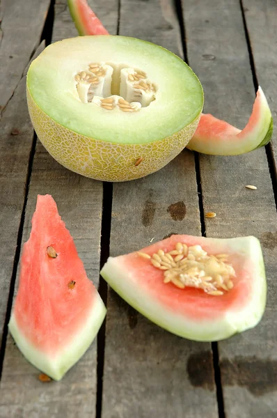 Watermelon and melon on gray wooden background — Stock Photo, Image