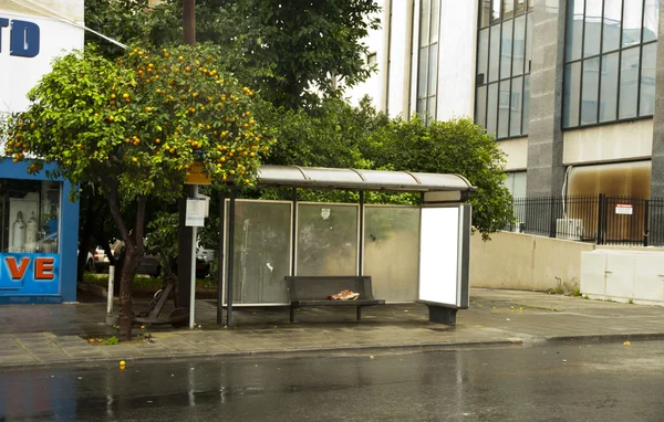 Arrêt de bus et arbre empilés d'oranges Images De Stock Libres De Droits