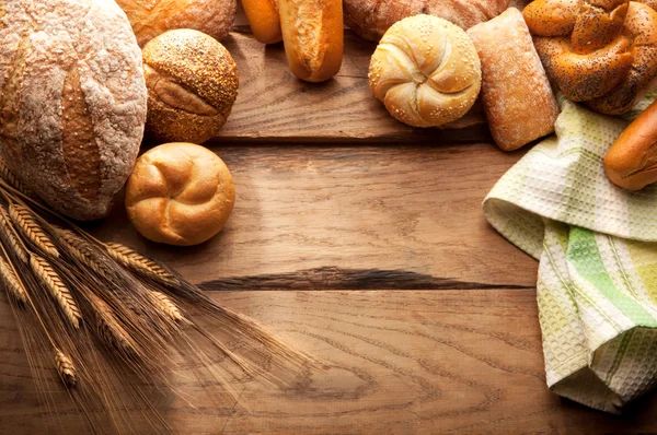 Verscheidenheid van brood op houten tafel — Stockfoto