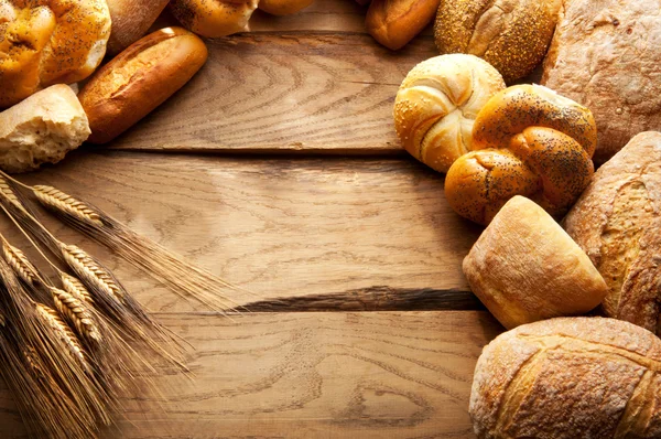 Verscheidenheid van brood op houten tafel Stockafbeelding