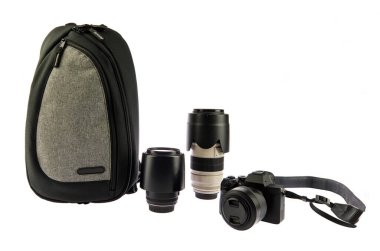 Boyun bantlı, geniş açılı objektifli ve beyaz arka planda şok geçirmez şehir fotoğrafçısı şok geçirmez su geçirmez sırt çantalı büyük siyah DSR kameranın izole edilmiş yakın çekim görüntüleri..