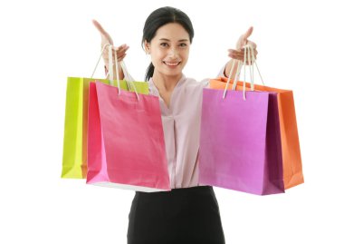 Portre kapalı çekim izole şehir modern Asyalı genç mutlu alışveriş kolik kadın alışveriş torbası gülümseyen ön beyaz arka planda mağazadan renkli kağıt alışveriş torbaları gösteren.