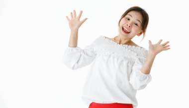 Asyalı şok edici bir stüdyo görüntüsü. Uzun kollu gömleği olan, ağzı açık duran, beyaz arka planda el ele tutuşan kameraya bakan saf bir kadın manken şaşırdı..