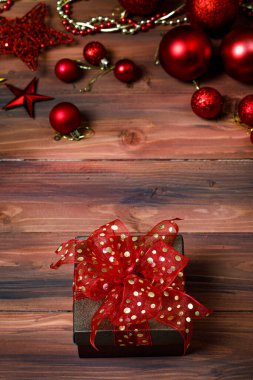 Hediyelik hediye kutusunun yakın plan görüntüsü. Altın kurdele yayı ile sarılmış. Öndeki parlak, parlak ahşap masaya yerleştirilmiş..