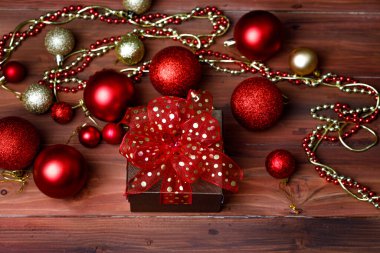 Hediyelik hediye kutusunun yakın plan görüntüsü. Altın kurdele yayı ile sarılmış. Öndeki parlak, parlak ahşap masaya yerleştirilmiş..