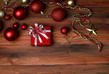 Hediyelik hediye kutusunun yakın plan görüntüsü. Altın kurdele yayı ile sarılmış. Öndeki parlak, parlak ahşap masaya yerleştirilmiş..