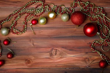 Noel festivalinin en iyi görüntüsü ve mutlu yeni yıl arifesi dekoratif eşyalar kırmızı parlak dekoratif toplar gümüş ampul boncuk zinciri ve eski siyah ahşap masa üzerine yerleştirilmiş parlak yıldız fotokopi alanı.