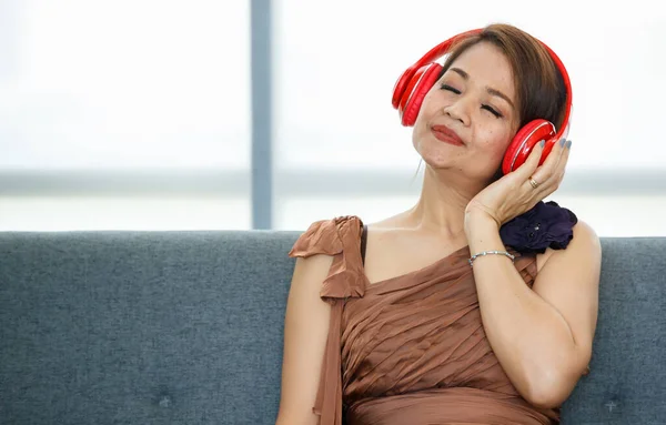 아시아 부유층 부유층 복장을 거실에 헤드폰을 집중력으로 음악을 — 스톡 사진
