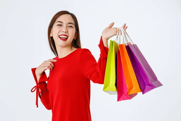 高兴地看到40多岁可爱的亚洲女人站在工作室里 手挽着彩色的购物袋 带着快乐快乐的白色背景的顾客看着相机 — 图库照片