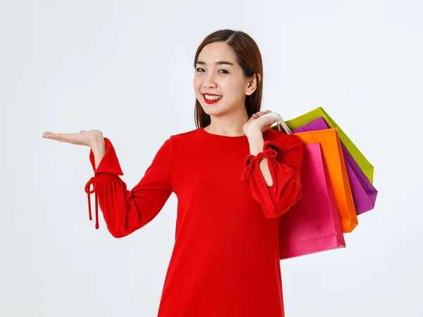 魅力的なアジアの女性の買い手とともにショッピングバッグは脇に白い背景にスタジオでと笑顔でカメラ — ストック写真
