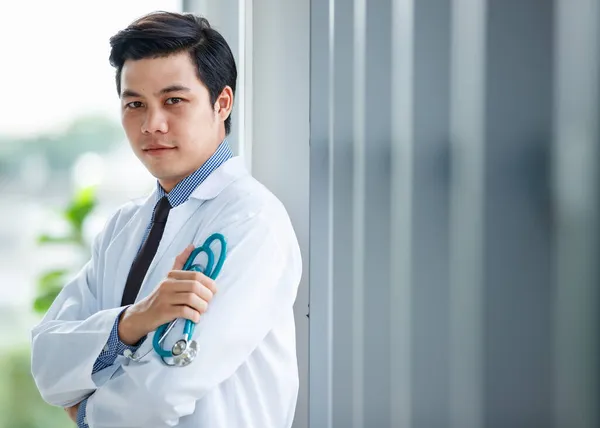 Vidám Fiatal Aranyos Ázsiai Férfi Orvos Egyenruhában Sztetoszkóppal Áll Klinikán — Stock Fotó