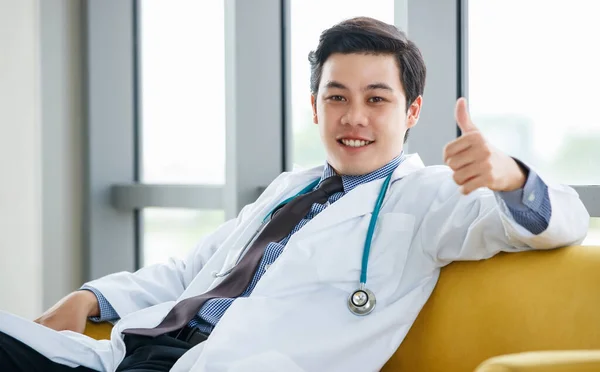 Confiado Médico Asiático Vestido Blanco Con Estetoscopio Sentado Sofá Pulgar — Foto de Stock