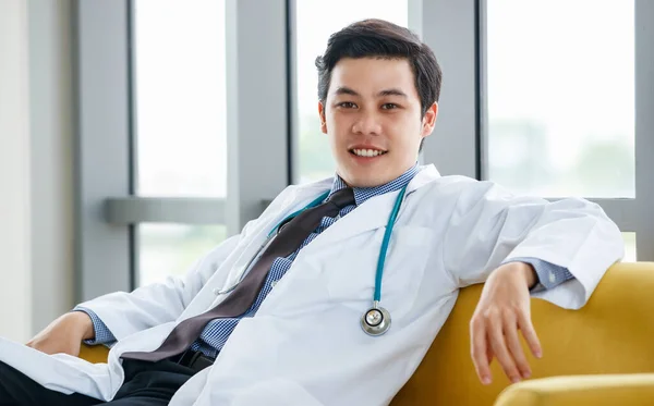 Sebevědomý Asijský Lékař Bílých Šatech Stetoskop Sedí Pohovce Opírá Ruku — Stock fotografie