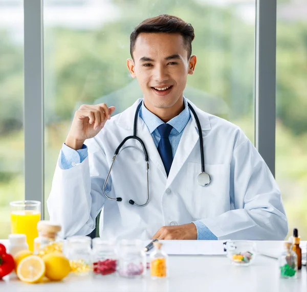 Usmívající Asijský Nutriční Lékař Sedí Stolu Pestrým Čerstvým Ovocem Dívá — Stock fotografie