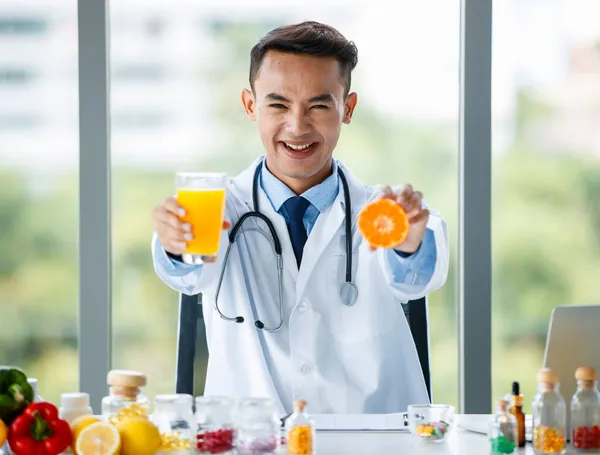 Hombre Asiático Uniforme Médico Demostrando Comparar Mitad Naranja Jugo Fresco — Foto de Stock