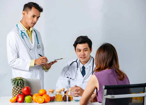 Tıp Üniformalı Asyalı Erkekler Kadınlarla Konuşuyor Modern Klinikte Sağlıklı Yiyeceklerle — Stok fotoğraf
