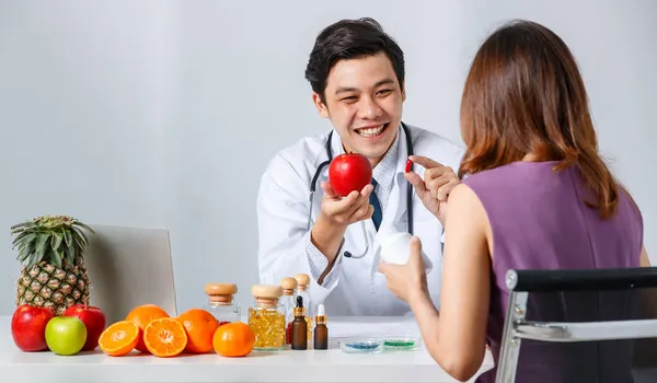 클리닉에서 비타민 광고를 하면서 아시아 의사와 — 스톡 사진