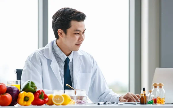 아시아의 영양학자는 음식을 가지고 현대식 사무실에 책상에 조깅을 하면서 — 스톡 사진