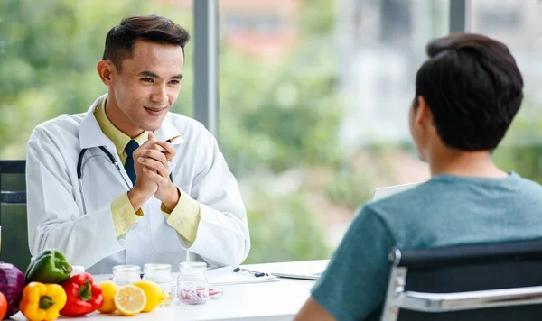 Asyalı Tıp Hekimi Hastanede Çalışırken Erkek Hastaya Bilgi Tavsiye Verir — Stok fotoğraf