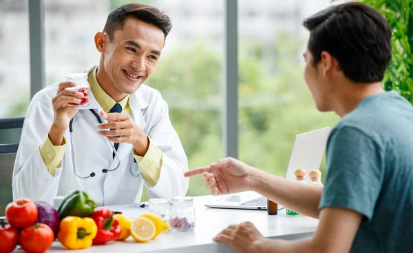 병원에서 근무하는 식탁에 미소를 사람에게 비타민 정제를 즐거움을 아시아 양학자 — 스톡 사진