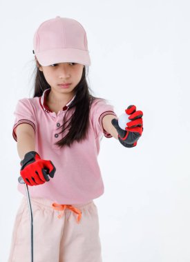 Portre, küçük Asyalı golfçünün pembe spor üniformalı ve şapkalı, kırmızı eldivenli ve elinde golf topuyla beyaz arka planda durduğu izole edilmiş bir fotoğraf..