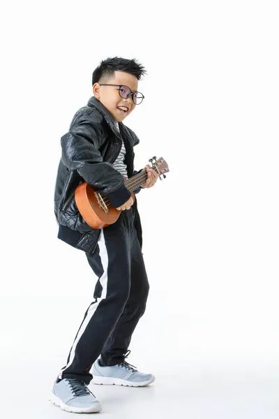 과검은 바지를 행복하게 기타를 부르고 함으로써 음악가 즐기는 아시아 소년의 — 스톡 사진