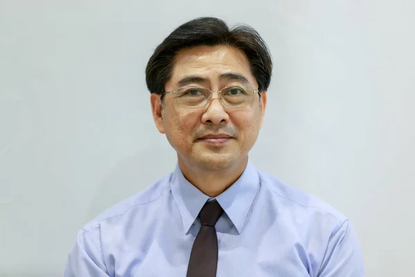 Portrait 50s healthy senior executive Asian businessman wearing glasses, shirt and necktie in a formal style, smiling happily and confidently in success, standing on white isolated background cutout
