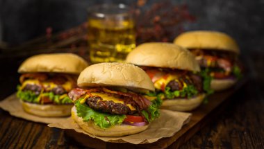 Köfte hamburgerler ahşap bir tahtanın üzerinde servis edilir ve tavan arasında bira servis edilir..