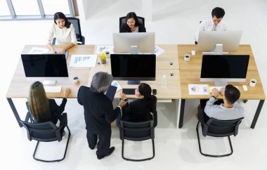 Bir grup iş adamı el ele verip başarılı amaçları, modern ofis ve teknoloji geçmişleri için takım çalışması tabelası hazırlıyorlar..