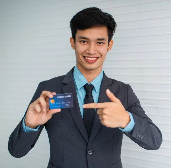 Joven Hombre Negocios Asiático Sonriendo Para Cámara Apuntando Tarjeta Crédito —  Fotos de Stock