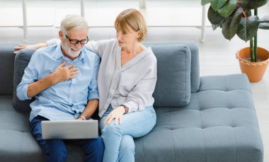 Kafkasyalı yaşlı, yaşlı, yaşlı, sevimli sevgili büyükanne, romantik çift, gri saçlı, sakallı karı koca, gülümseyen komedi filmi seyrederek evde, oturma odasında kanepede birlikte oturuyorlar..