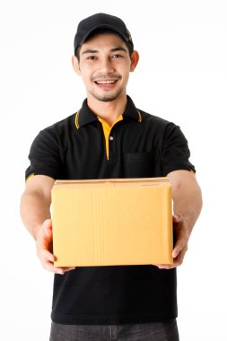 Neşeli Asyalı teslimatçı paketi iki elinde tutuyor, kameraya gülümsüyor. İzole edilmiş beyaz arka planda siyah üniformalı kurye portresi. E-ticaret iş konsepti