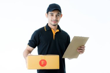 Çekici Asyalı teslimatçı paketi sağ elinde ve teslimat kağıdı sol elinde tutuyor. İzole edilmiş beyaz arka planda siyah üniformalı kurye portresi. E-ticaret iş konsepti