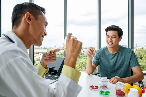 병원에서 근무하는 식탁에 미소를 사람에게 비타민 정제를 즐거움을 아시아 양학자 — 스톡 사진