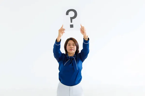 Doubtful female officer staff in business suit look at camera holding  big question mark paper cardboard sign raise overhead showing curiosity thinking for answers on white background.