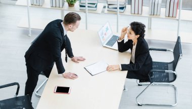 Milenyum Kafkasyalı başarılı düşünceli iş adamı ve iş kadını takım elbiseli iş arkadaşı şirket işyerindeki beyin fırtınası çözüm fikirlerini tartışıyorlar..