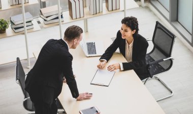 Milenyum Kafkasyalı başarılı düşünceli iş adamı ve iş kadını takım elbiseli iş arkadaşı şirket işyerindeki beyin fırtınası çözüm fikirlerini tartışıyorlar..