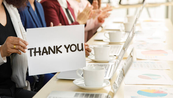 Группа деловых женщин, сидящих за рабочим столом, хлопающих в ладоши и выражающих благодарность за то, что оценили кого-то в современной офисной компании. Концепция хороших обстоятельств в компании с коллегами.