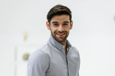 Portre yetişkin yakışıklı beyaz sakallı iş adamı ya da kısa saçlı, temiz gömlekli, kameraya bakan, mutluluk ve güvenle gülümseyen, ayakta duran fotoğraf stüdyosu