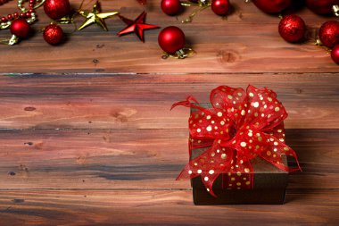 Hediyelik hediye kutusunun yakın plan görüntüsü. Altın kurdele yayı ile sarılmış. Öndeki parlak, parlak ahşap masaya yerleştirilmiş..