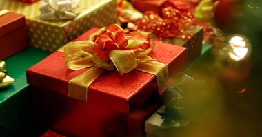 Renkli ambalaj kağıdıyla sarılmış güzel lüks hediye kutusu, kurdele, yaratıcı büyüleyici yayla süslenmiş, özel bir hediye grubu olarak yığılmış ve Noel partisi için bir hatıra.