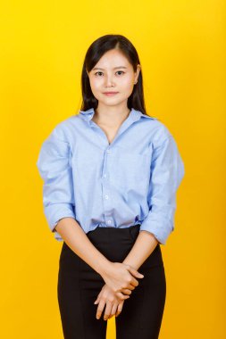 Genç ve sevimli Çinli, Japon tarzı bir kadının portresi kameraya olumlu bir jest ve sarı kamerada dostane bir gülümsemeyle poz veriyor..