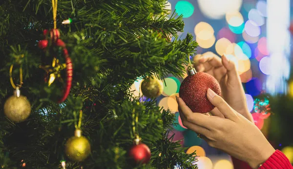 Noel Baba süveterli bir kadın eli Noel ağacına renkli bir süs ve balo asarak mutlu bir gecede muhteşem bir kutlama partisi düzenliyor. Eski tarz resme uyması için biraz gürültü ekle.