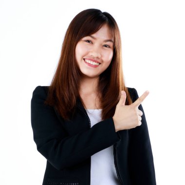 Genç ve yeni mezun olmuş, takım elbiseli Asyalı iş kadını reklam jesti olarak poz veriyor, mal ve ürünleri göstermek veya sunmak için boş bir alanı işaret ediyor. Beyaz arkaplanda izole